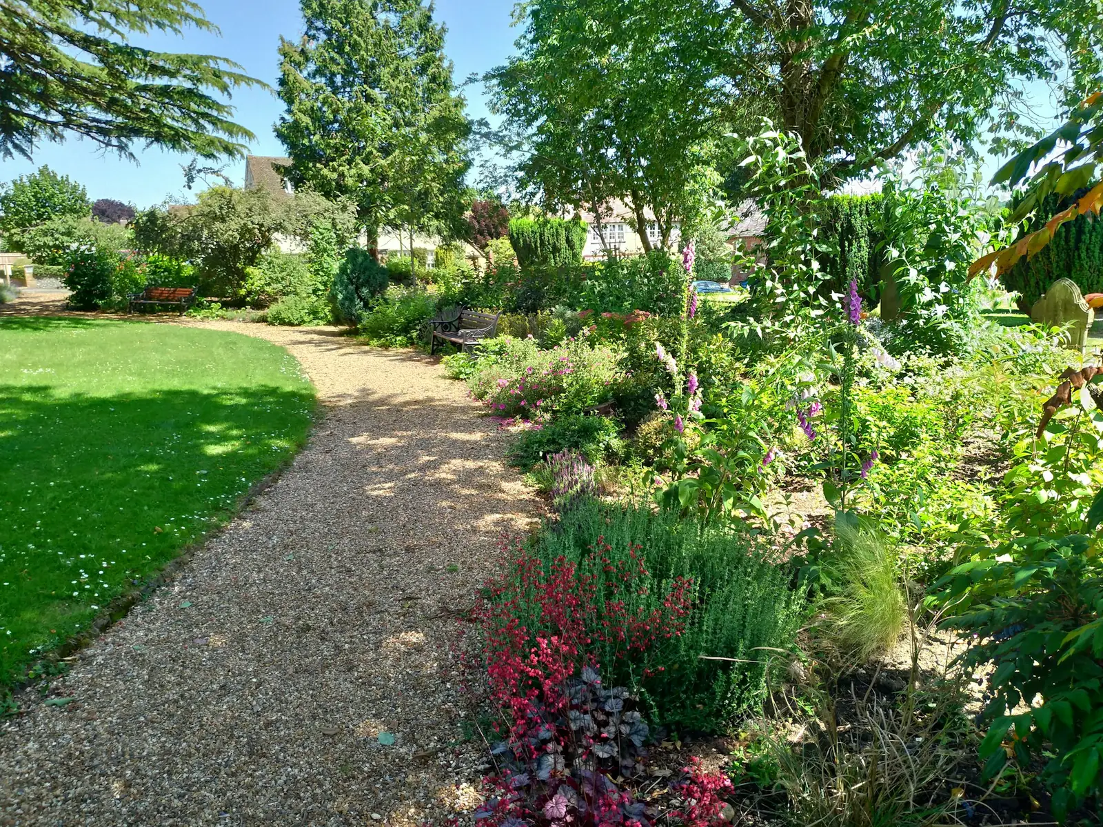 A finished rear garden with a level lawn, planted borders and a paved seating area